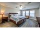 Comfortable main bedroom with a ceiling fan, large windows, and hardwood furniture at 9814 Palazzo St, Seffner, FL 33584
