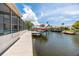 View of the private backyard with screened in pool and boat dock on the canal at 9909 San Mateo Way, Port Richey, FL 34668