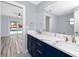 Bright bathroom featuring double sinks, marble countertops and a view of the pool at 9909 San Mateo Way, Port Richey, FL 34668
