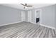 Bedroom with wood-look floors showing access to doors and a partial view of a bathroom with navy blue vanity at 9909 San Mateo Way, Port Richey, FL 34668