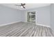 Spacious bedroom featuring wood-look floors and sliding glass doors with pool view at 9909 San Mateo Way, Port Richey, FL 34668
