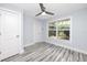 Light filled bedroom with ceiling fan, and a view of the landscaped yard through the window at 9909 San Mateo Way, Port Richey, FL 34668