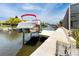 View of the boat and lift on the private dock and canal at 9909 San Mateo Way, Port Richey, FL 34668
