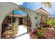 Close up of a charming home entrance featuring lush landscaping, a decorative gate, and a well-maintained walkway at 9909 San Mateo Way, Port Richey, FL 34668