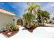 Charming home entrance with lush landscaping, a decorative gate, and a well-maintained walkway leading to the front door at 9909 San Mateo Way, Port Richey, FL 34668