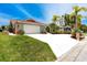 Inviting single-story home showcasing lush landscaping, a red tile roof, and a spacious driveway leading to the garage at 9909 San Mateo Way, Port Richey, FL 34668