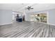 Open-concept living room flows into a modern kitchen and features sliding glass doors to a screened-in pool area at 9909 San Mateo Way, Port Richey, FL 34668