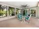 Inviting screened-in patio with a ceiling fan and outdoor dining set, perfect for relaxing at 9909 San Mateo Way, Port Richey, FL 34668