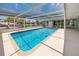 Sparkling pool with an extended screened-in patio, ideal for swimming and relaxation at 9909 San Mateo Way, Port Richey, FL 34668