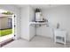 Bright utility room featuring a water heater, laundry sink, and access to the outdoors at 9909 San Mateo Way, Port Richey, FL 34668