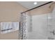 Shower-tub combination with white tile and contemporary shower curtain in well-lit bathroom at 10217 Westpark Preserve Blvd, Tampa, FL 33625