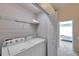 Functional laundry area with washer and dryer, including storage shelving and access to bedroom at 10217 Westpark Preserve Blvd, Tampa, FL 33625