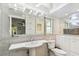 Bright bathroom featuring tile walls, large mirror, pedestal sink and toilet at 10387 Majestic Dr, Largo, FL 33774