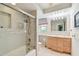 Bright bathroom featuring tiled walls, glass enclosed shower, and a single sink vanity at 10387 Majestic Dr, Largo, FL 33774