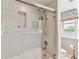 Bathroom featuring tiled walls, glass enclosed shower, and a decorative window shade at 10387 Majestic Dr, Largo, FL 33774