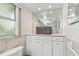 Bathroom featuring tile walls, large mirror, white vanity, and toilet at 10387 Majestic Dr, Largo, FL 33774