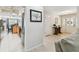 Hallway with tile flooring leading to the kitchen and front entrance, adorned with a decorative mirror and wood table at 10387 Majestic Dr, Largo, FL 33774