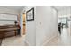 Hallway featuring neutral walls, tile flooring, artwork, and leading to the kitchen and dining area at 10387 Majestic Dr, Largo, FL 33774