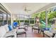 Enclosed screened patio featuring cozy seating, fan, backyard view and playground at 10387 Majestic Dr, Largo, FL 33774