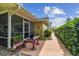 View of the outdoor patio and screened in porch featuring lush landscaping and brick pavers at 10387 Majestic Dr, Largo, FL 33774