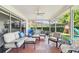 Spacious screened patio with ceiling fan, comfortable seating, and view of play set at 10387 Majestic Dr, Largo, FL 33774