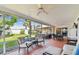 Relaxing screened patio with ceiling fans, comfortable seating, and a view of the backyard at 10387 Majestic Dr, Largo, FL 33774