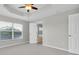 Bedroom with neutral carpet, tray ceiling with ceiling fan, and lake views through the window at 11617 Colony Lake Dr, Tampa, FL 33635