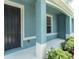 A well kept blue porch featuring a black front door, white columns and green shrubbery at 11617 Colony Lake Dr, Tampa, FL 33635