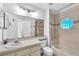 Bathroom featuring vanity, toilet, tub-shower with unique window, and tile flooring at 11816 Cedarfield Dr, Riverview, FL 33579