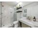 Bright bathroom features a glass-enclosed shower with marble tile surround and modern vanity with stone countertop at 1400 Tarpon Woods Blvd # E4, Palm Harbor, FL 34685