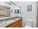 Bathroom featuring granite countertops, a tiled shower, and a framed mirror at 1400 Tarpon Woods Blvd # E4, Palm Harbor, FL 34685