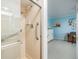 Shower with accessibility features and a partial view of an adjacent blue bedroom at 1400 Tarpon Woods Blvd # E4, Palm Harbor, FL 34685