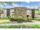 Apartment complex featuring a unique stone facade, well-manicured landscaping, and a welcoming entrance at 1400 Tarpon Woods Blvd # E4, Palm Harbor, FL 34685