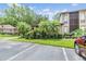 Well-maintained condo complex with mature trees, tropical plants, and designated parking, enhancing its curb appeal at 1400 Tarpon Woods Blvd # E4, Palm Harbor, FL 34685