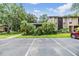 Well-maintained condo complex with mature trees, tropical plants, and designated parking, enhancing its curb appeal at 1400 Tarpon Woods Blvd # E4, Palm Harbor, FL 34685