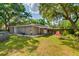 Spacious backyard with a covered patio, seating area, and partially fenced yard at 1403 W Pradera Ave, Tampa, FL 33612