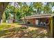 The backyard features an orange door covered patio, a covered area, and lush trees at 1403 W Pradera Ave, Tampa, FL 33612