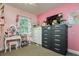 Bright pink bedroom features a vanity, dresser and TV, and is decorated in a fun and colorful design at 1403 W Pradera Ave, Tampa, FL 33612