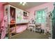 Bright pink bedroom with lofted play area, vanity, and window providing natural light and a playful design at 1403 W Pradera Ave, Tampa, FL 33612