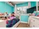 Turquoise bedroom with a cozy bed, lots of stuffed toys, and a window providing natural lighting at 1403 W Pradera Ave, Tampa, FL 33612