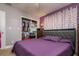 Bedroom showcases a comfortable bed, closet with organized storage, and a purple accent wall at 1403 W Pradera Ave, Tampa, FL 33612