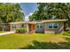 Inviting single-story home featuring freshly cut green grass, and trimmed bushes by the front entrance at 1403 W Pradera Ave, Tampa, FL 33612