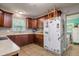 Functional kitchen with wooden cabinetry, and bright lighting, providing ample counter space at 1403 W Pradera Ave, Tampa, FL 33612