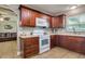 Well-lit kitchen featuring wood cabinets, light countertops, and a view into the living area at 1403 W Pradera Ave, Tampa, FL 33612