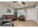 Relaxing living room with neutral decor, tile floors, ceiling fan, and comfortable leather furniture at 1403 W Pradera Ave, Tampa, FL 33612