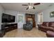 Cozy living room with neutral walls, tile flooring, a ceiling fan, and stylish, comfortable seating at 1403 W Pradera Ave, Tampa, FL 33612