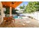 Beautiful patio area featuring travertine tile, outdoor seating, an umbrella, and lush landscaping at 1427 40Th Ne Ave, St Petersburg, FL 33703