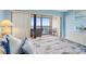 Bright bedroom with balcony access and water views, furnished with a comfortable bed, table and chairs at 14950 Gulf Blvd # 905, Madeira Beach, FL 33708