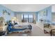 Bright bedroom featuring light blue walls, slider to balcony, and furniture, offering a relaxing coastal ambiance at 14950 Gulf Blvd # 905, Madeira Beach, FL 33708