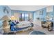 Bright bedroom featuring light blue walls, slider to balcony, and furniture, offering a relaxing coastal ambiance at 14950 Gulf Blvd # 905, Madeira Beach, FL 33708
